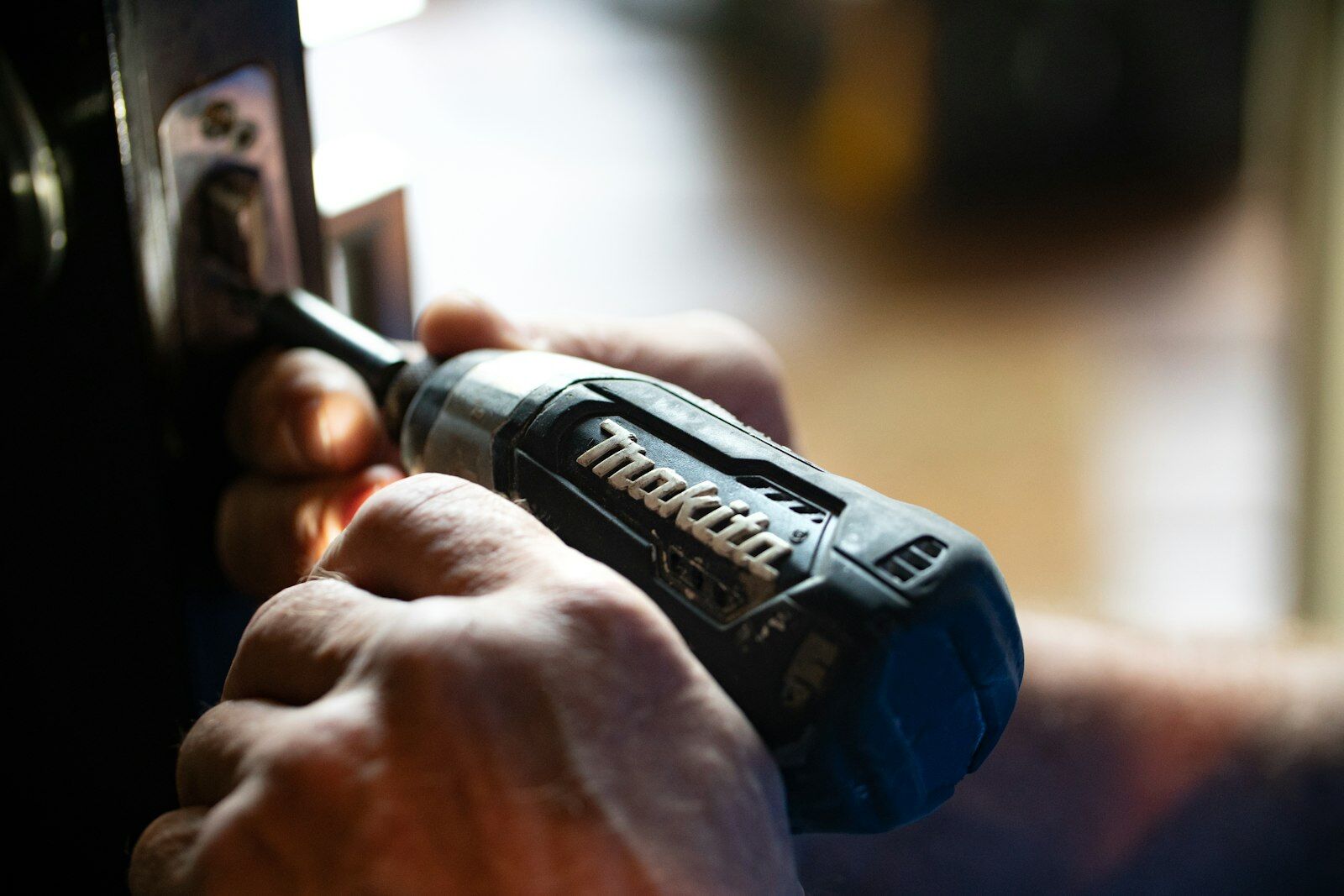Electric screwdriver working next to a door lock